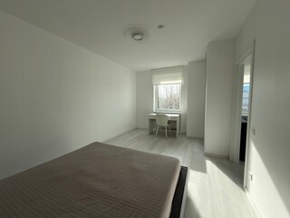 Bright minimalist bedroom with desk by window and natural light