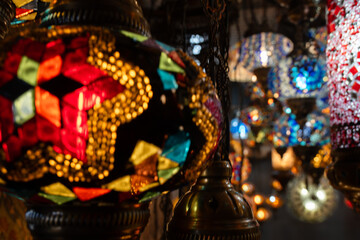 Fototapeta premium Lamps, Mosaic, Turkey: Colorful Turkish mosaic lamps displayed market stall, nighttime.