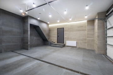 Garage with automatic gates on the ground floor of a private house. Spacious room with modern decoration.