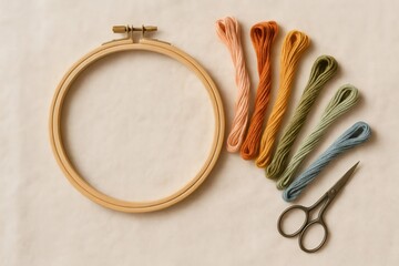 Embroidery hoop, colorful floss, and scissors arranged on a plain fabric background, showing needlecraft essentials