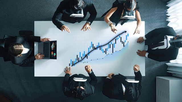 A business team utilizes virtual reality technology to analyze financial growth data in a modern office setting, showcasing innovative collaboration and engagement. Axiom - Powered by Adobe