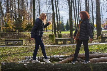 Friends balancing on log together