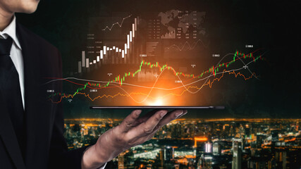 A businessman in a suit holds a digital tablet displaying vibrant data visualizations, charts, and graphs with an illuminated city skyline in the background. Scalp