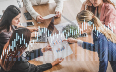 A group of professionals engages in a collaborative business meeting, focusing on charts and graphs that illustrate important financial data and trends. Scalp