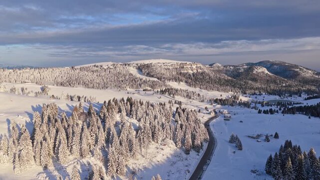 Panorama invernale aereo con neve ripreso da drone sopra Passo Coe sull'Alpe Cimbra di Folgaria nelle Alpi del Trentino-Alto Adige in Italia mentre i cannoni sparano neve