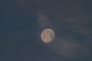 Full moon in frosty winter morning with blue sky
