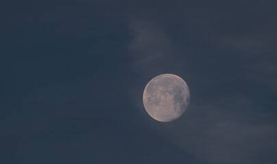 Full moon in frosty winter morning with blue sky