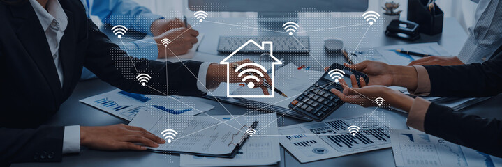 Business professionals engage in a lively discussion about digital home connectivity, analyzing data and strategizing future projects in a modern office environment. Gantry