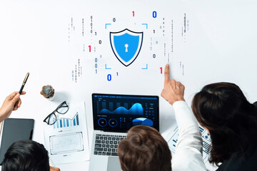 Professionals collaborate on cybersecurity strategies utilizing data analysis and insights displayed on a laptop, focusing on digital protection in the modern workspace. Trope