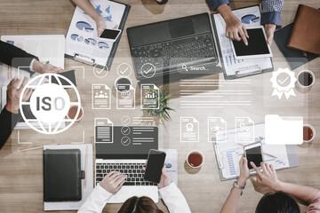 A modern office setting featuring teamwork and collaboration with digital devices while discussing ISO guidelines, enhancing workflows and productivity through effective project management. Gantry