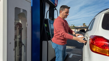 Man refueling car at gas station pump