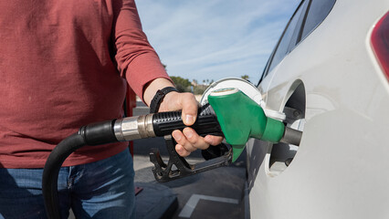 Person refueling car at gas station pump