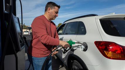 Man refueling white suv car at gas station