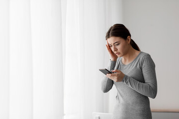 Sad despaired young european lady receiving bad news on smartphone at home interior. Smartphone...