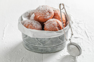 Hot and tasty mini doughnuts deep frying in oil.