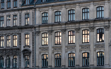 Naklejka premium Classic European Apartment Building Facade with Window Reflections at Sunset