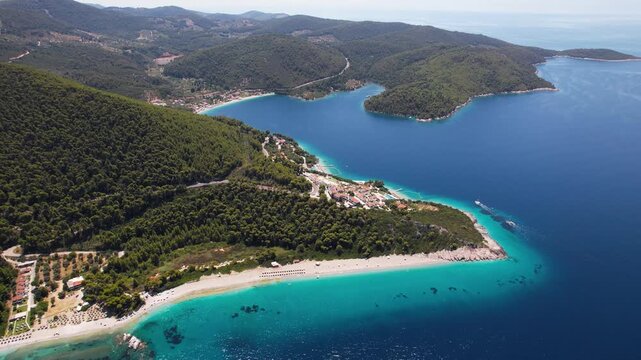 High angle aerial view of Kastani, Milia and Panormos beaches on Skopelos island, Greece. Coastal landscape with turquoise sea and lush pine forests.