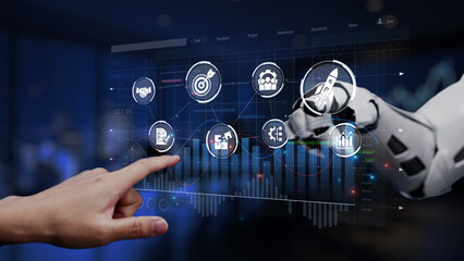 A futuristic robot arm interacts with a digital touchscreen display featuring data analysis graphs and icons, representing the intersection of health and technology in modern business. Synapse