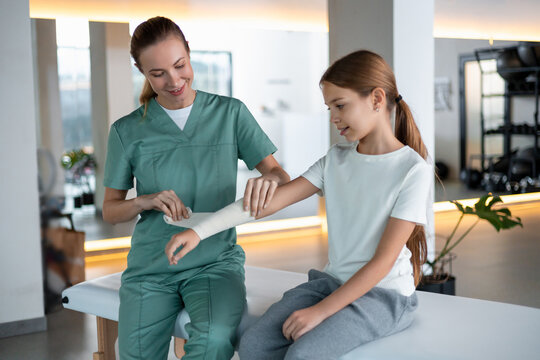 Pediatric patient receiving professional arm bandage care - Powered by Adobe