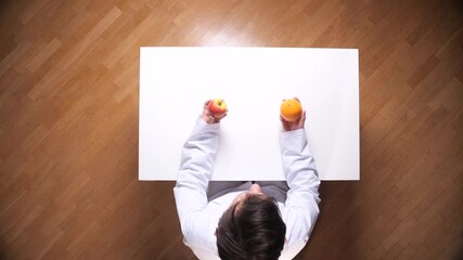 Healthcare professional wearing a lab coat holding an apple and an orange, symbolizing a dietary decision or nutritional evaluation for a balanced and healthy lifestyle