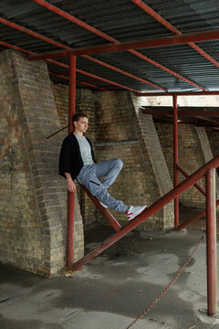 Casual young man moving and waiting in an urban industrial interior