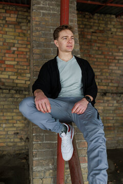 Casual young man moving and waiting in an urban industrial interior