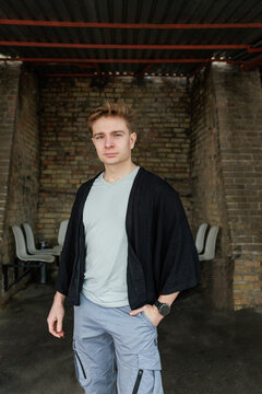 Casual young man moving and waiting in an urban industrial interior