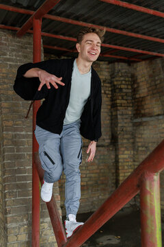 Casual young man moving and waiting in an urban industrial interior