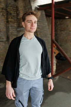 Casual young man moving and waiting in an urban industrial interior