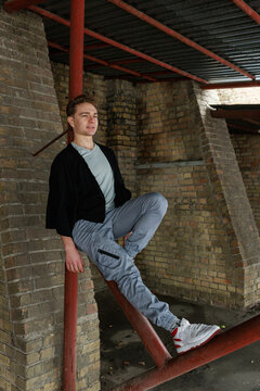 Casual young man moving and waiting in an urban industrial interior