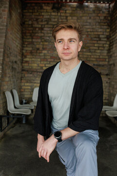 Casual young man moving and waiting in an urban industrial interior