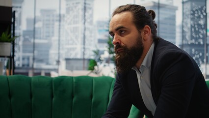 Male corporate leader buries his face in his hands due to frustration, pressure of a declining economy and battling the stress of a failing company. Business downfall and bankruptcy. Camera A.