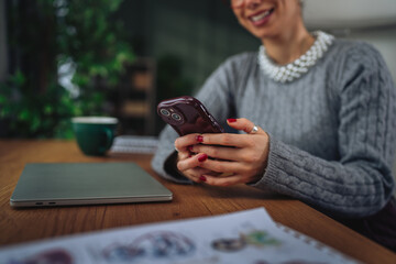 Woman communicating on smart phone at workplace desk