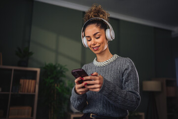 Fototapeta premium Young woman listening to music relaxing at home