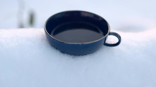 Simple tea cup placed in cold snow, minimal winter scene with calm mood, silence and clean natural background