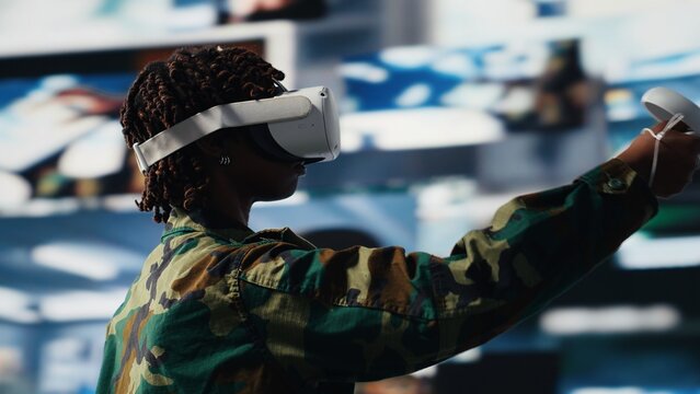 Military operator in war room oversees mission operations using virtual reality technology. Army soldier using VR headset equipment to do surveillance and threat monitoring, camera B - Powered by Adobe