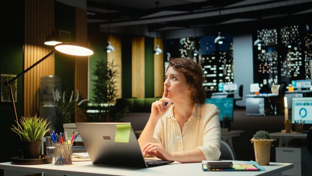 Genius businesswoman making a breakthrough discovery late at night, having a spark of the moment with a new innovative idea. Enlightenment and originality with a brilliant approach. Camera A.