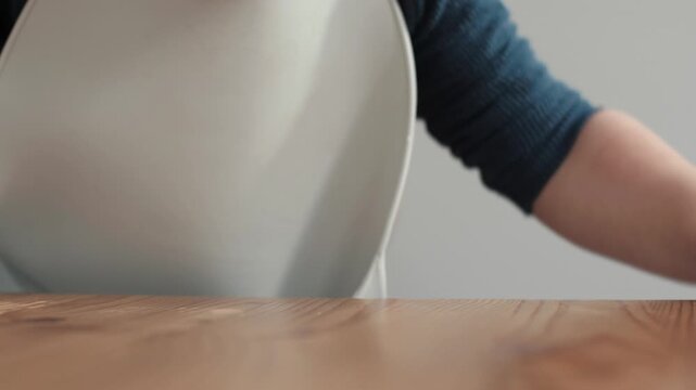 Child exploring feelings, Baby at table exhibits curiosity with slight frustration amid mealtime, An inquisitive young child at table displays exploratory behavior despite minor annoyance