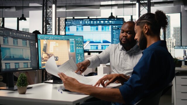 Engineer and designer working together on real estate interior design, using software for professional layout and structure. Creating master plans and reviewing construction blueprints.
