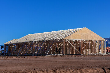 Construction workers inside a wood framed building under development, representing residential construction, interior structural assembly, and active building operations