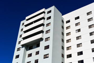 Modern high-rise residential building with balconies against a clear sky, representing urban housing development, multifamily real estate, and contemporary architecture