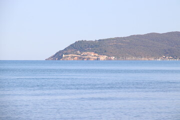 Fototapeta premium Beautiful scenic view of a wild and empty sandy beach in Albinia, Maremma region, Grosseto province, Tuscany, Italy. Blue sea and Mediterranean coastline under a clear sky.