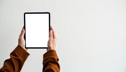 Two hands hold a modern tablet with a blank white screen. Person uses a portable digital device for browsing or working remotely. Modern tech gadget with empty display for content.