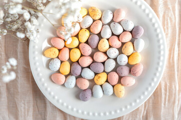 Spring composition with colorful chocolate Easter eggs. Easter concept. Creative festive holiday layout. Flat lay, top of view. High quality photo