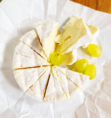 Cheese and grapes served on a paper plate at gathering