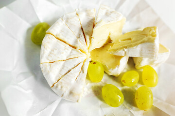 Cheese and grapes on white paper plate