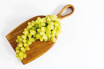 Green grapes on a wooden cutting board
