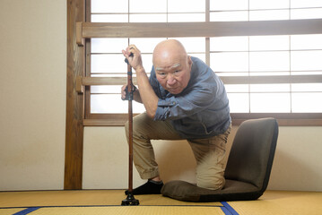 杖を使用して室内でリハビリをしている老人