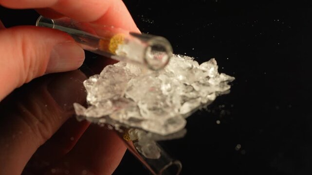 Drug user holding crack pipe with crystal drug concept. Preparation for consumption of Fentanyl, Cocaine, Crystal meth or Crack Cocaine