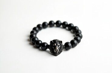 Obraz premium Black shungite bracelet displays lion head element. Stylish accessory features dark beads on white background. Elegant jewelry is suitable for men. The close up photo provides artistic details.